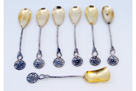 Conjunto de seis colheres de café em prata  e pá de açúcar recortadas com as conchas em dourado.